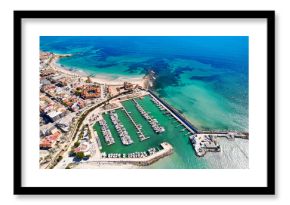 Aerial view coastal spanish town of Torre de la Horadada with houses rooftops, turquoise bay of Mediterranean Sea and harbor with vessels during sunny day. Costa Blanca, Alicante province. Spain