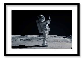 WIDE Male actor in astronaut suit making selfie on a Moon Lunar movie shooting set. Shot with 2x anamorphic lens