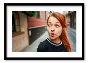 Portrait of funny red-haired woman pouting