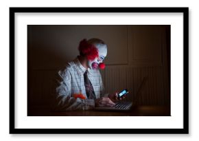 Clown wearing a shirt and tie uses a laptop computer and smart phone simultaneously  Lincoln, Nebraska, United States of America