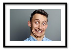 A man laughing hysterically at something hilarious with a funny expression on his face.