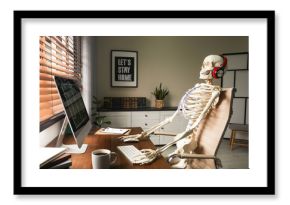 Human skeleton with headphones using computer at workplace