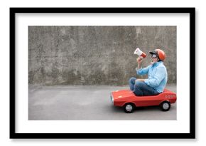 Funny businessman driving retro pedal car outdoor