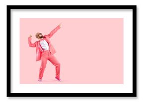 Cheerful successful man dancing funny making movements winner isolated on pink background. Funny man in pink formal suit celebrates his success having fun at copy space. Full length. Banner.