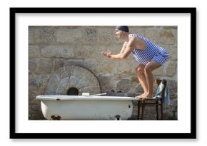 man in retro swimsuit jumps to the outdoor bathtub
