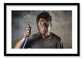 young man holding  cable smoking after electrical accident with dirty burnt face in funny sad expression