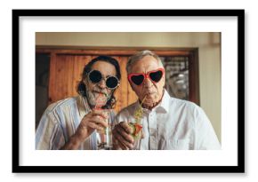 Retired men wearing funny sunglasses drinking juice