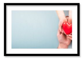 The adult and the child holding red heart.