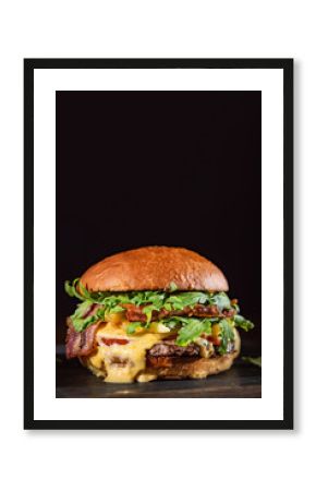 Homemade beef burger with crispy bacon and vegetables on rustic serving board