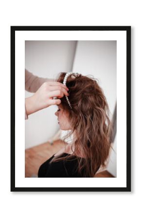 the hairdresser puts the girl's hair, jewelry made of pearls