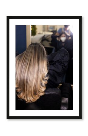 woman in back with new look at the hairdresser's. long hair with light highlights