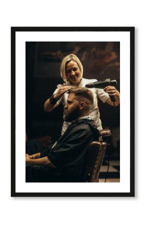 Young bearded man getting haircut by hairdresser