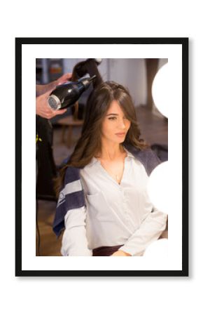 Woman getting new hairstyle done by hairdresser in the modern hair salon.