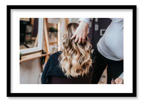 Beautiful hairstyle of young woman after dyeing hair and making highlights in hair salon.