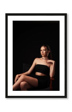 Portrait of a young girl on a dark background. Beauty, clean skin, stylish earrings