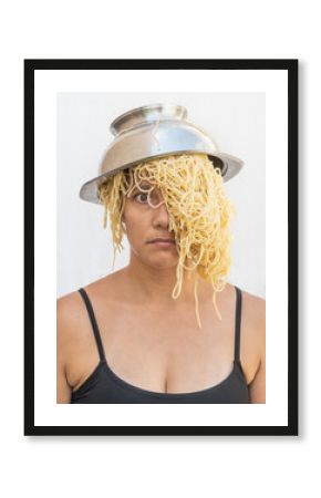 woman with a strainer of spaghetti on her head as a hat and spaguetti as hair wig. mental chaos concept