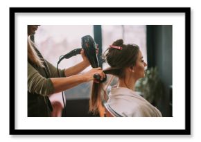 Hairdresser drying client hair at the salon