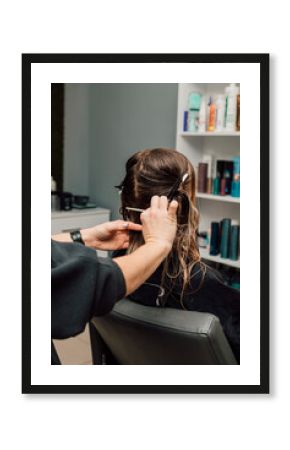 A hairdresser cuts a blonde's hair in a beauty salon. Women's haircut