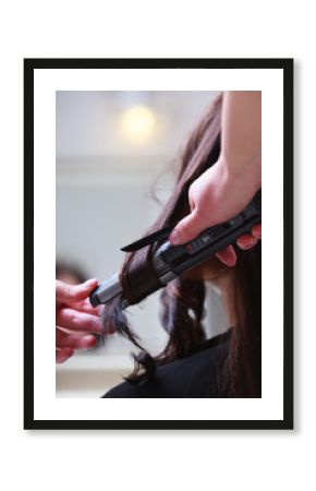In hairdressing salon. Female hair and straightening irons.