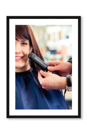 Friseur frisiert Frau die Haare im Friseursalon