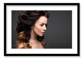 Loki, włosy pełne objętości. Portret pięknej kobiety na czarnym tle.