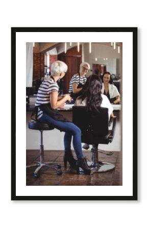 Hair stylist sitting with client at the hair salon