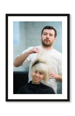 male hairdresser puts woman's hair in a hairdressing salon