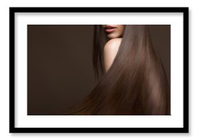 Beautiful brunette girl in move with a perfectly smooth hair, and classic make-up. Beauty face. Picture taken in the studio.