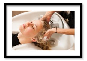 Hair stylist at work - hairdresser washing hair to the customer