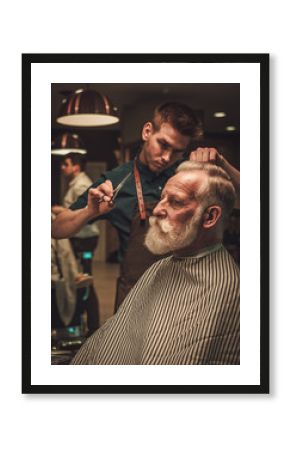 Confident senior man visiting hairstylist in barber shop.