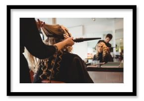 Female hairdresser styling clients hair
