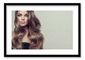 Brunette  girl with long  and  volume shiny wavy hair .  Beautiful woman model with curly hairstyle .