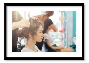 Hairdresser combing hair bun