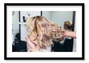 Beautiful hairstyle of young woman after dying hair and making highlights in hair salon.