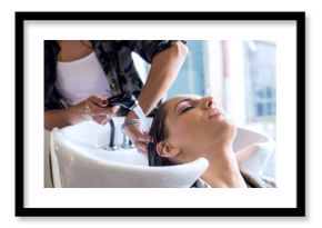 Working day inside the hair salon, hairdresser washing hair. 