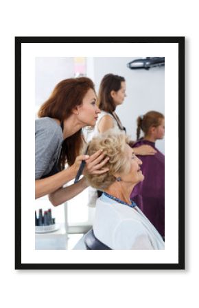 Hairdresser doing styling of senior woman