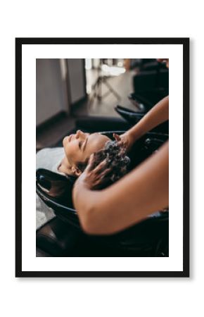 Beautiful young woman getting a hair wash. Hair salon styling concept.