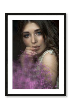 Beautiful brunette girl with a bouquet of flowers close-up