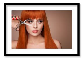 Beautiful young woman with a bright makeup and a smooth long hair holds metal scissors. Model with red hair. Hair salon, haircut. Care and beauty hair products. Perfect make-up