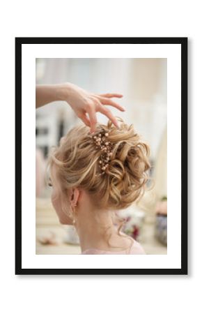Makeup artist, hair professional stylist makes young beautiful bride bridal makeup before wedding in a morning