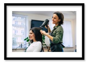 Happiness from new hairstyle. Close-up shot of a happy smiling professional stylist drying and combing hair of her satisfied client.