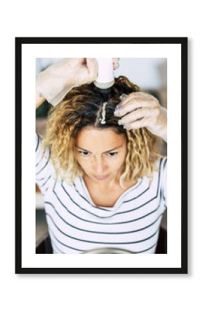 Beautiful adult young woman prepare and use hair dye to color and have care - beauty wellness activity at home - stay at home concept for coronavirus emergency worldwide pandemic contagion