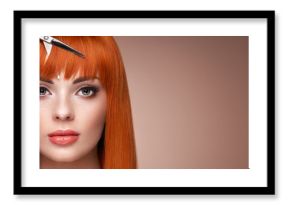 Beautiful young woman with a bright makeup and a smooth long hair holds metal scissors. Model with red hair. Hair salon, haircut. Care and beauty hair products. Perfect make-up