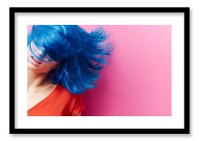 studio portrait of a sexy beautiful girl with a smile in motion on a pink background. Girl with blue hair