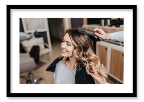 Beautiful hairstyle of young woman after dyeing hair and making highlights in hair salon.