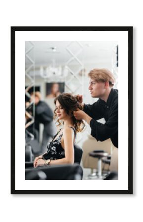 In a beautiful, modern beauty salon, a professional stylist makes a haircut and hairstyle for a young girl. Beauty, and fashion