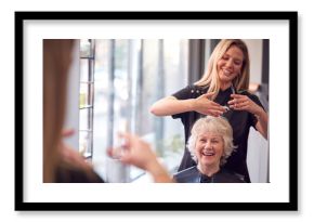 Senior Woman Having Hair Cut By Female Stylist In Hairdressing Salon
