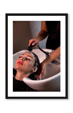 Hairdresser hands wash adult woman head with shampoo in spa salon for create hairstyle. Hairstylist washing hair in barber shop. Concept of customer service at hair salon, haircare. Copy ad text space