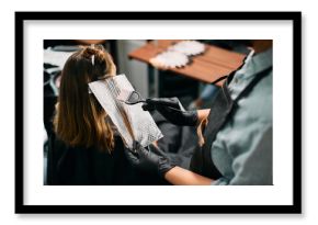 Close-up of hairdresser dyes customer's hair at the salon.