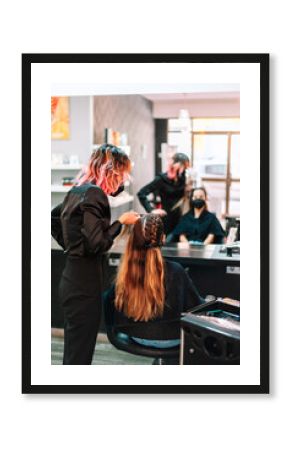 Woman hairdresser making braids to client